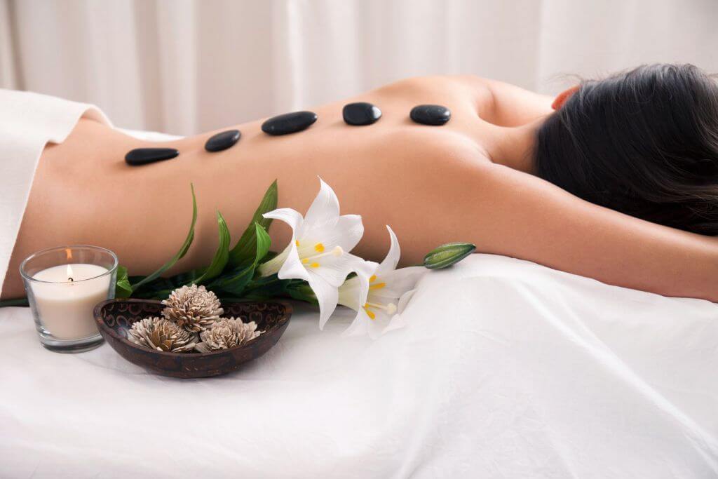 Massage đá nóng tại spa ở TPHCM với đá bazan xếp dọc sống lưng